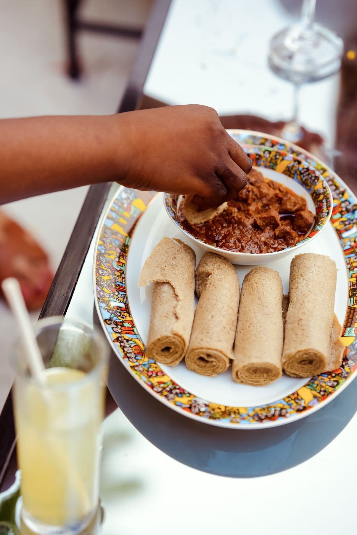 Hands sharing injera during a meal at ge'eza